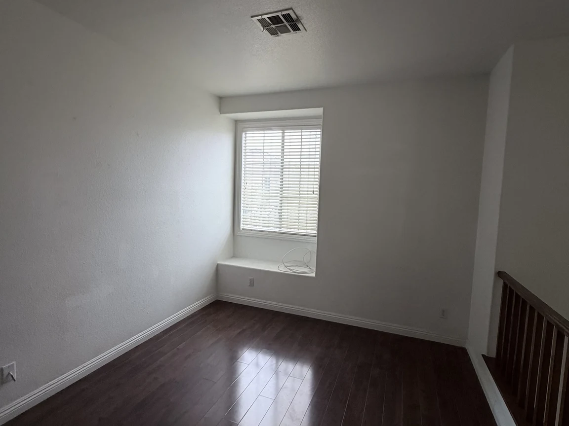 Before: upstairs landing with window and dark wood floor